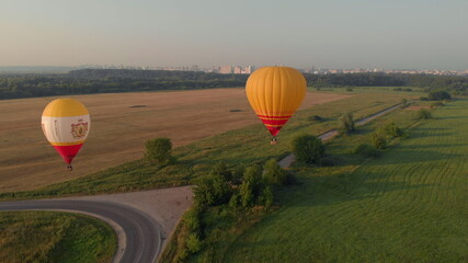 High altitude aerial drone wide view. A collection of hot air balloons are flying through a clear blue sky on a morning in Ryazan, Russia 18 july 2021