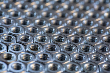 pattern of aligned bolt nuts. macro photography. blurred background. free space to write. can be used as background for presentations