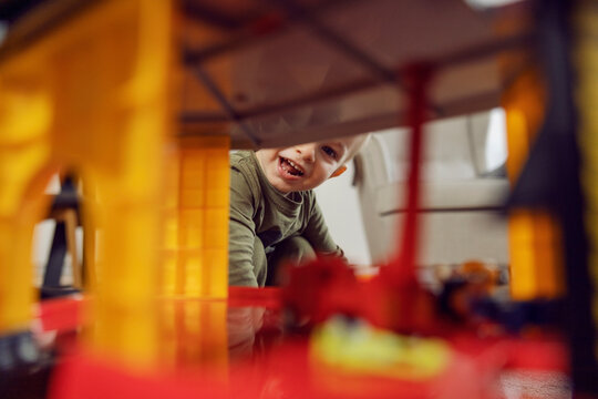 The boy smiles, baby face. A picture of a boy playing with toys indoors. A happy childhood in kindergarten, child development. Educating children in kindergartens, playing games and growing up