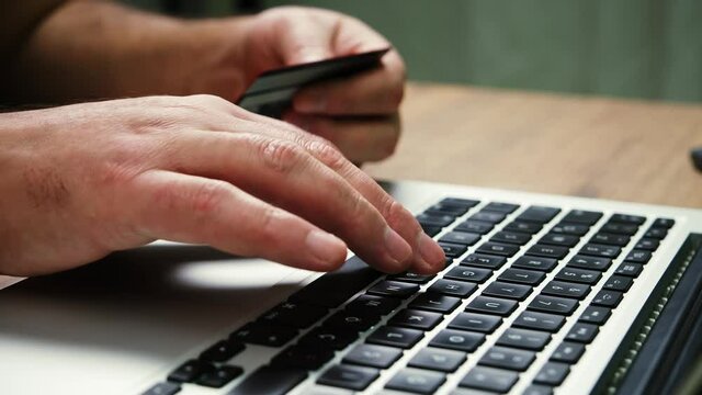 Man hands of cardholder holding credit card making e bank online payment. Woman consumer paying for purchase in web store using laptop technology. E Commerce website payments concept.