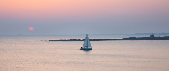 Bateau naviguant sur l'eau avec un coucher de soleil à la trinité sur mer en bretagne france