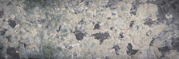 Peeling paint on the wall. Panorama of a concrete wall with old cracked flaking paint. Weathered rough painted surface with patterns of cracks and peeling. Wide panoramic grungy texture for background