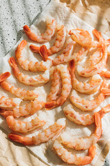 raw de-shelled prawns shrimp with tails on paper towel in the sun 