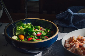 lettuce salad with tomato, radish in blue bowl 