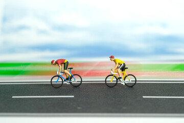 Miniature people toy figure photography. Fast movement motion bicycle. A biker cycling on a track...