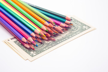 set of colored pencils for drawing on a dollar background. sales marketing