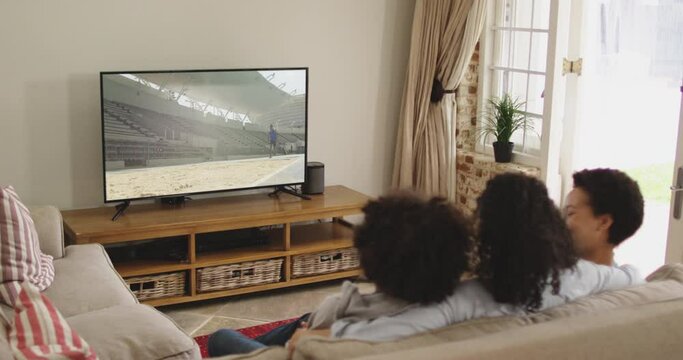Composite of happy family sitting at home together watching long jump athletics on tv