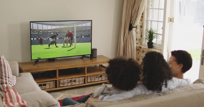 Composite of happy family sitting at home together watching rugby match on tv