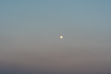 moon at sunset with a pink and blue sky background