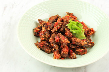 Close up Oseng Pedas Paru (Spicy Stir Fry Beef Lung), Dishes Made from Beef Lungs Cooked in Spicy Sauce and Herbs. Served in a Ceramic Plate.
