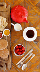 Healthy continental breakfast, cenital view, cup of tea, wholemeal bread, gluten free biscuits, milk, jam, honey