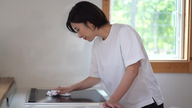 クッキングヒーターの拭き掃除をする女性