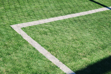 Synthetic soccer field, green with white lines, located outdoors.