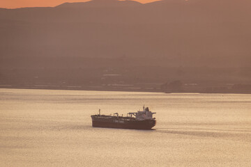 Sunset colors with a cargo ship travelling in the Messenian Gulf in southern Greece