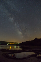 milky way over reservoir lake with old roman thermal springs Os banos de Bande, Spain
