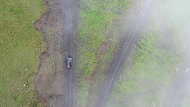 Downward angle drone shot of vehicle driving on the Abano Pass in Tusheti Georgia