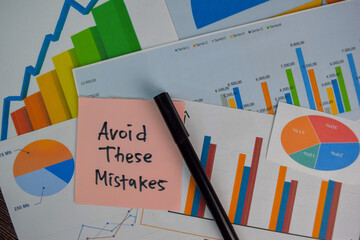 Avoid These Mistakes write on sticky notes isolated on Wooden Table. Stock market concept