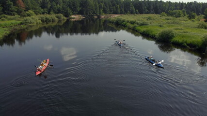 Tracking a Boat. Tourist base of kayaks and canoes, summer adventure kayak, rafting to canoe. Kayaking top view. Group of kayaks rowing together. Aerial view from drone.