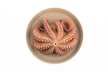 There is a boiled octopus on the plate. The background is white.