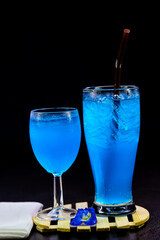 glass of blue hawaii isolated on wooden plate