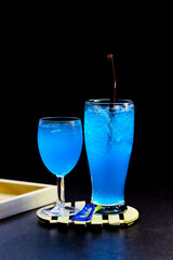 glass of blue hawaii isolated on wooden plate
