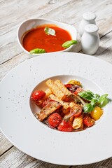 Close-up traditional penne pasta with tomatoes, spices, Parmesan cheese and fresh basil. Dish of classic Italian cuisine in a white plate on a wooden background. Vertical shot. Copy space. Top view