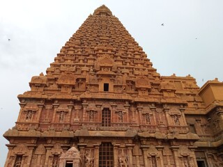 The main tower of the ancient Hindu temple of Brihadeeshwarar/ Thanjai Big Temple with beautiful carvings and crowds of tourists.