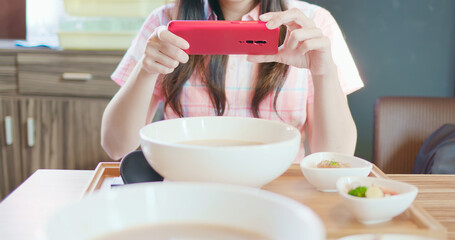 woman take picture of ramen noodles
