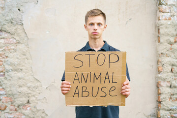 Stop animal abuse guy holding a cardboard box with the inscription. Animal activist. Caucasian...