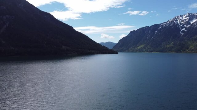 Sunrise by amazing glacial lake Achensee in mountains Alps aerial view.