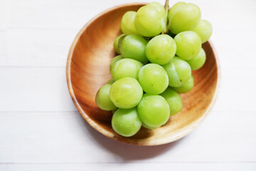 green grape on wooden dish and table background. Fresh organic concept. Shine Muscat, grape, fresh green, natural, natural food, Healthy.