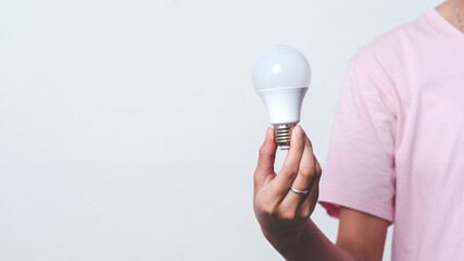 Close up hand of woman holding light bulb with copy space.