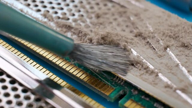 Cleans from dust memory module for PC with contact pins. Heat spreader transfer energy to heat sink or exchanger. Service center worker. Random Access Memory or electronic board RAM