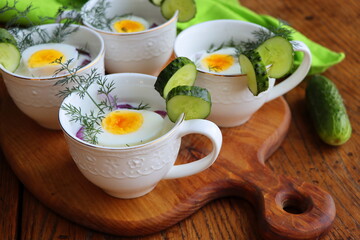 Cold soup with cucumbers, yogurtl and fresh herbs on the wooden rustic table