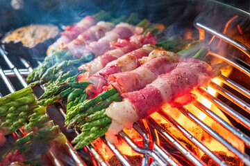 Prosciutto wrapped green asparagus on a grilling pan - obrazy, fototapety, plakaty