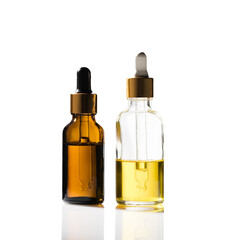 Two filled glass cosmetic bottles with dispensers - one brown, the other transparent. The background is isolated.