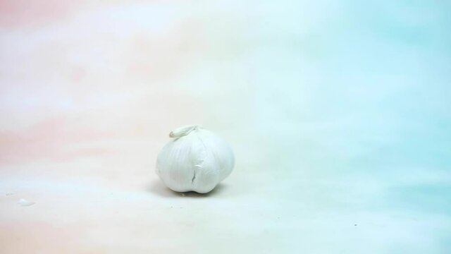 Slow motion and panning of fresh garlic rolling rolling into. Close-up.