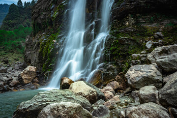 waterfall white water stream falling from mountains at day from flat angle