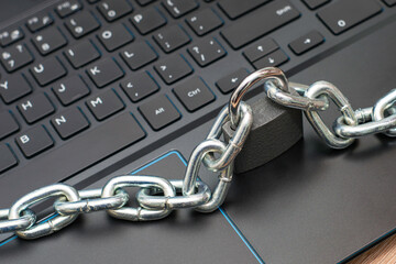 an iron chain fastened with a padlock on a computer keyboard the concept of data protection censorship on the Internet