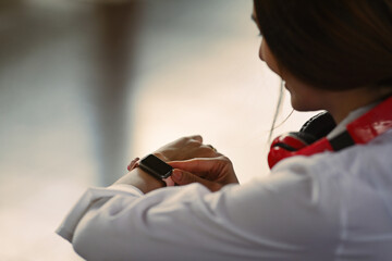 Close up of woman traveler checking time on her smartwatch.