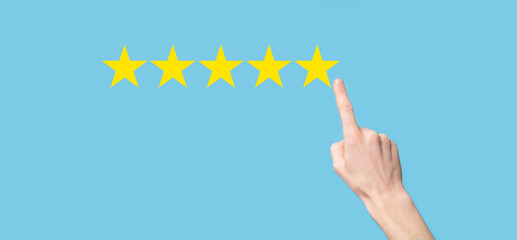 Man holds smart phone in hands and gives positive rating, icon five star symbol to increase rating of company concept on blue background.Customer service experience and business satisfaction survey.