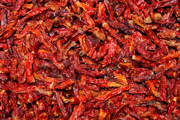 Close-up many fresh dried red chili peppers,  a popular Asian spice for cooking to make a spicy flavor, on top-view background