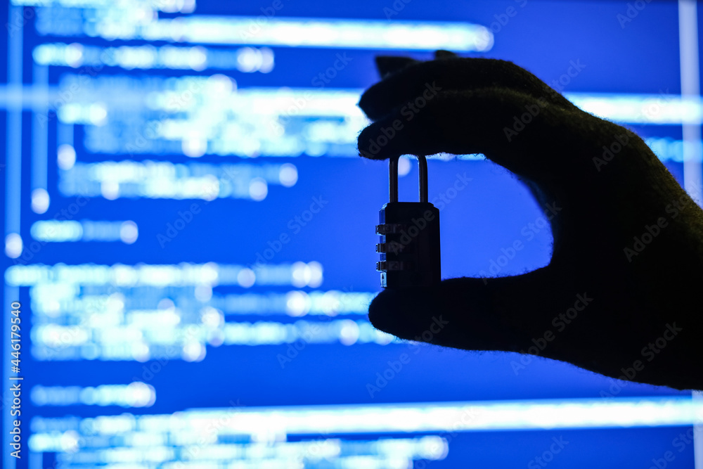 Wall mural hand of hacker with padlock near screen of computer