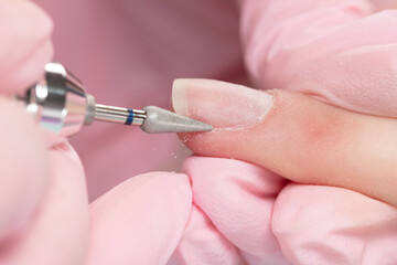 Close up process of applying red varnish. Woman in salon receiving manicure by nail beautician. Red...