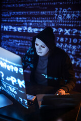 Hacker using computers in dark room