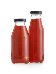 Bottles of chili sauce on white background