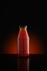 Bottle of chili sauce on dark background