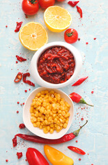 Bowl of tasty salsa sauce and products on color background