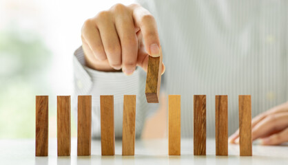Woman Hand stopping wooden domino business crisis effect or risk protection concept,