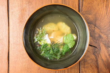 Soup Kharcho, traditional Georgian soup, checken broth in a bowl over rustic wooden background.